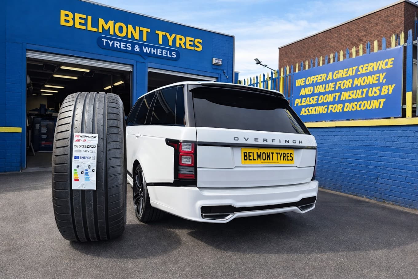 A premium tyre and a white Range Rover outside Belmont Tyres' blue Liverpool shopfront